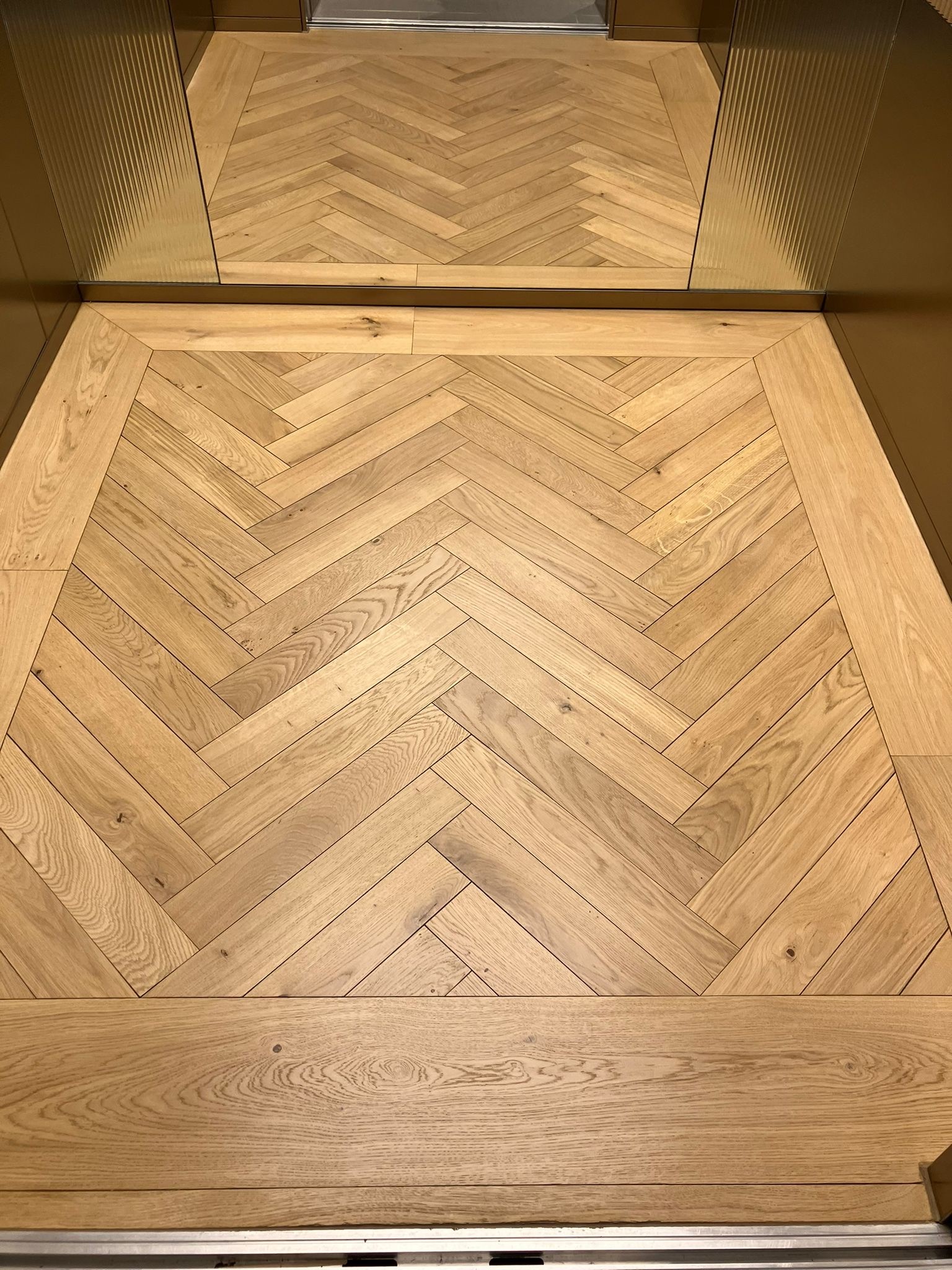 Finished timber floor inside lift after restoration works - Loughton Direct